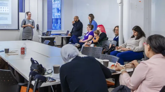 A librarian presenting to a seated group in a workshop room